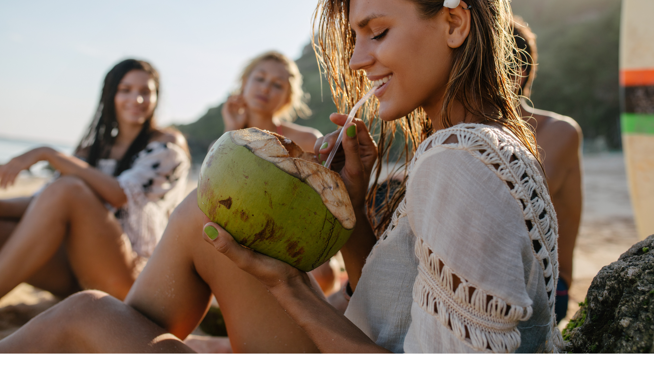 girl drinking coconut water from a green coconut
